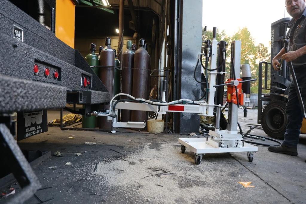 Core drill rig extended from truck in workshop bay