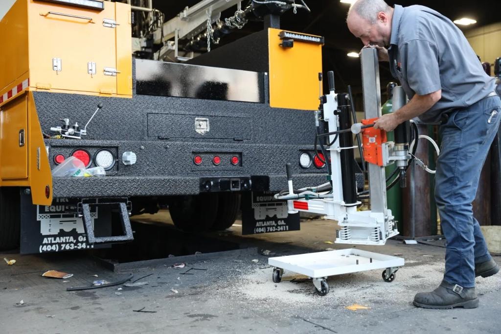 Technician operating core drill on City of Atlanta yellow truck